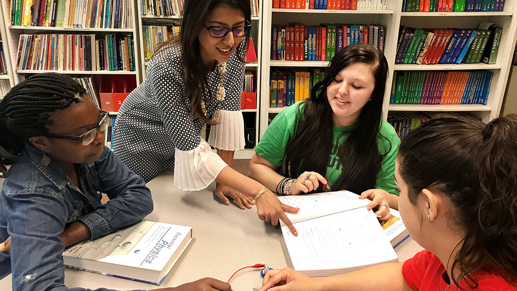 A female teacher teaching three young girls