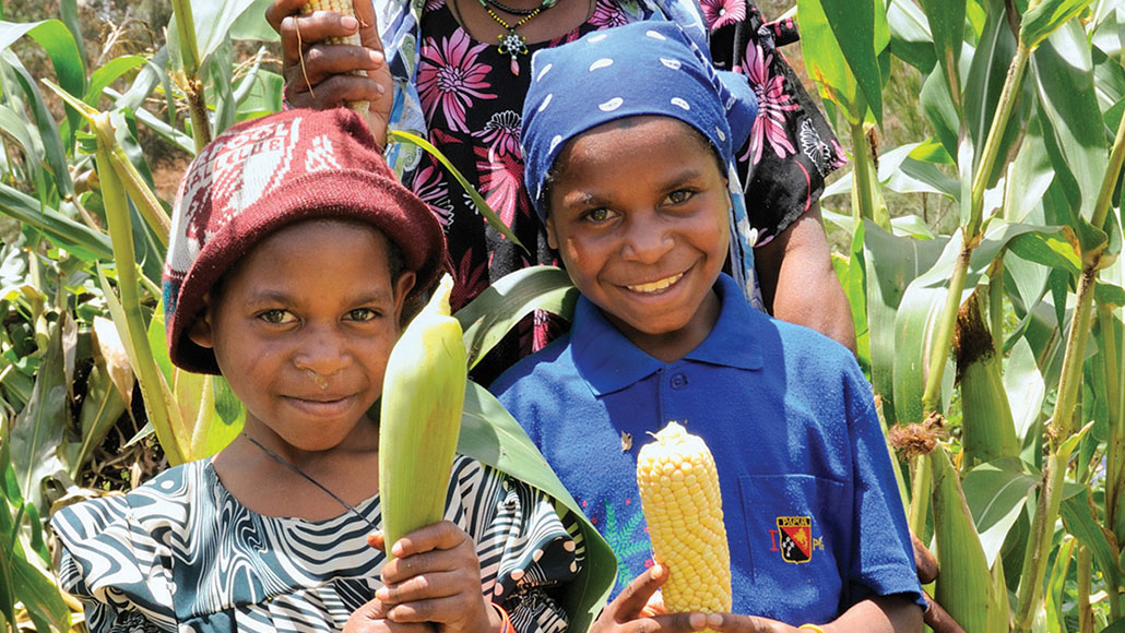 Children on a farm with corn