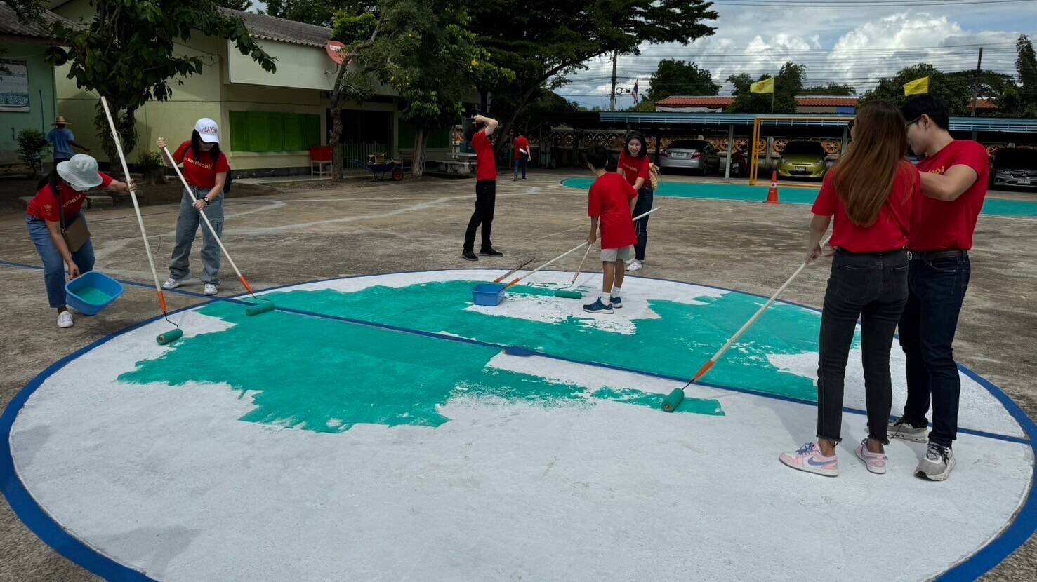 Volunteer employees painting the football ground.