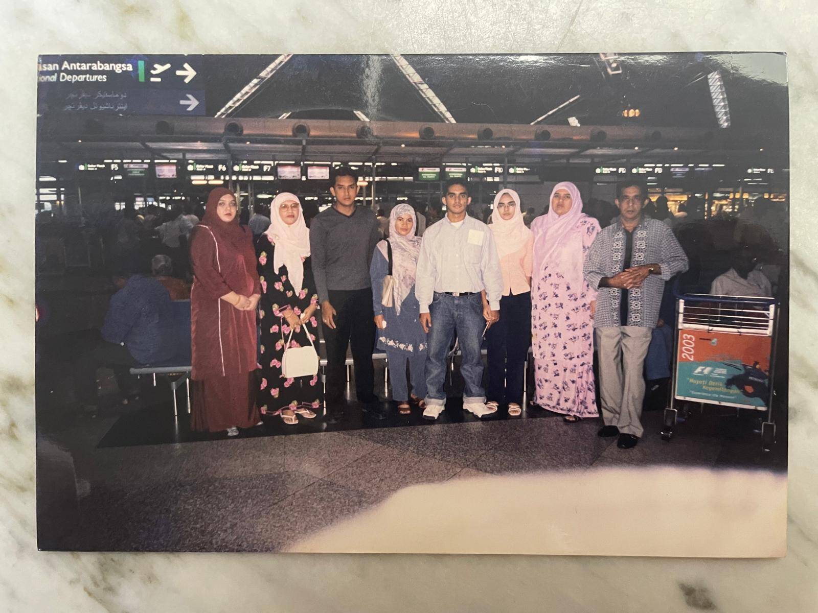 A young Hazizi bids farewell to his family in the airport departure hall, as he prepares to fly to the U.K. for his studies, marking the start of an important new chapter in his life.